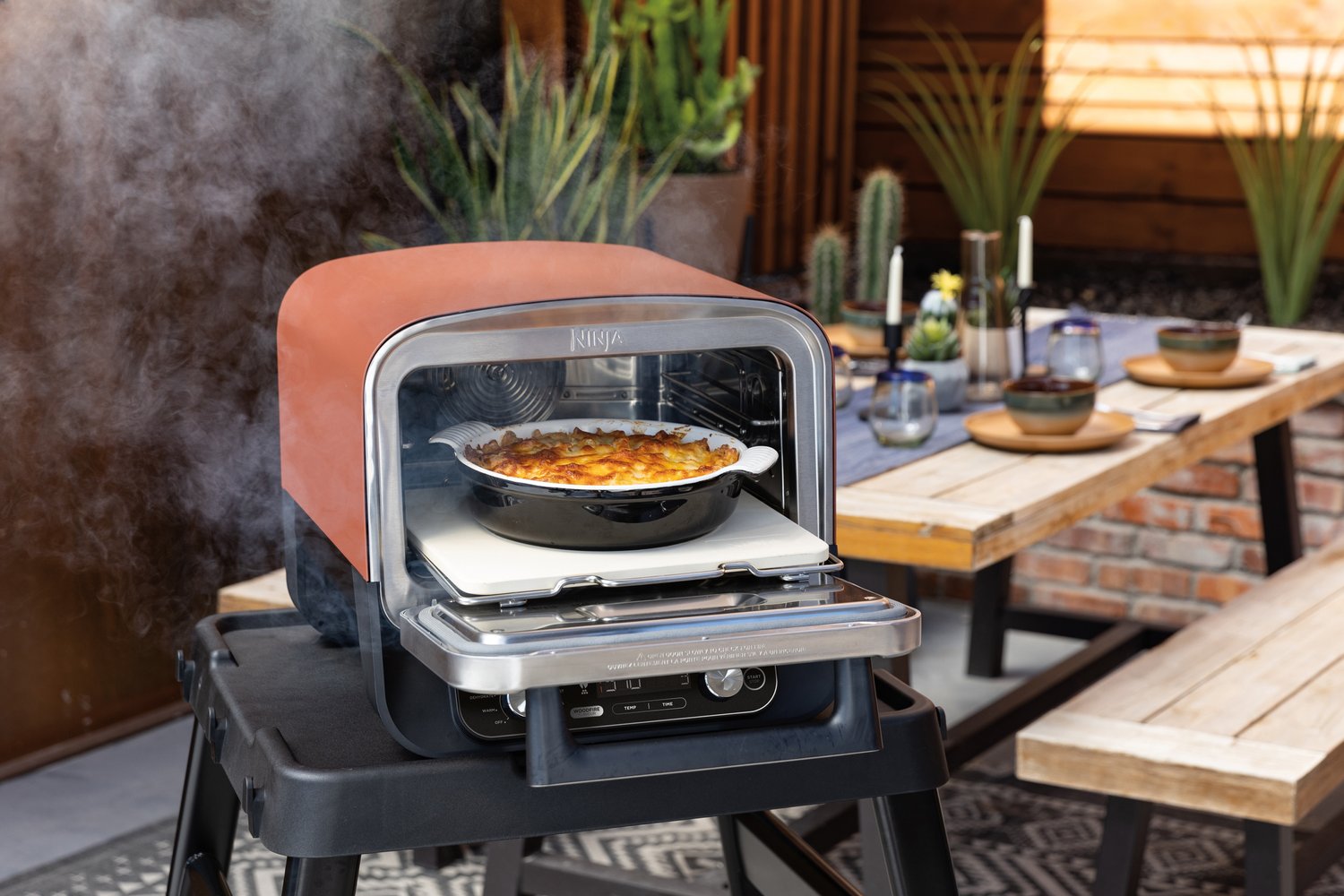 Ninja-OO101UK_InUse_PatioTable_OnStand_Open_MacCheese_RT+RGB