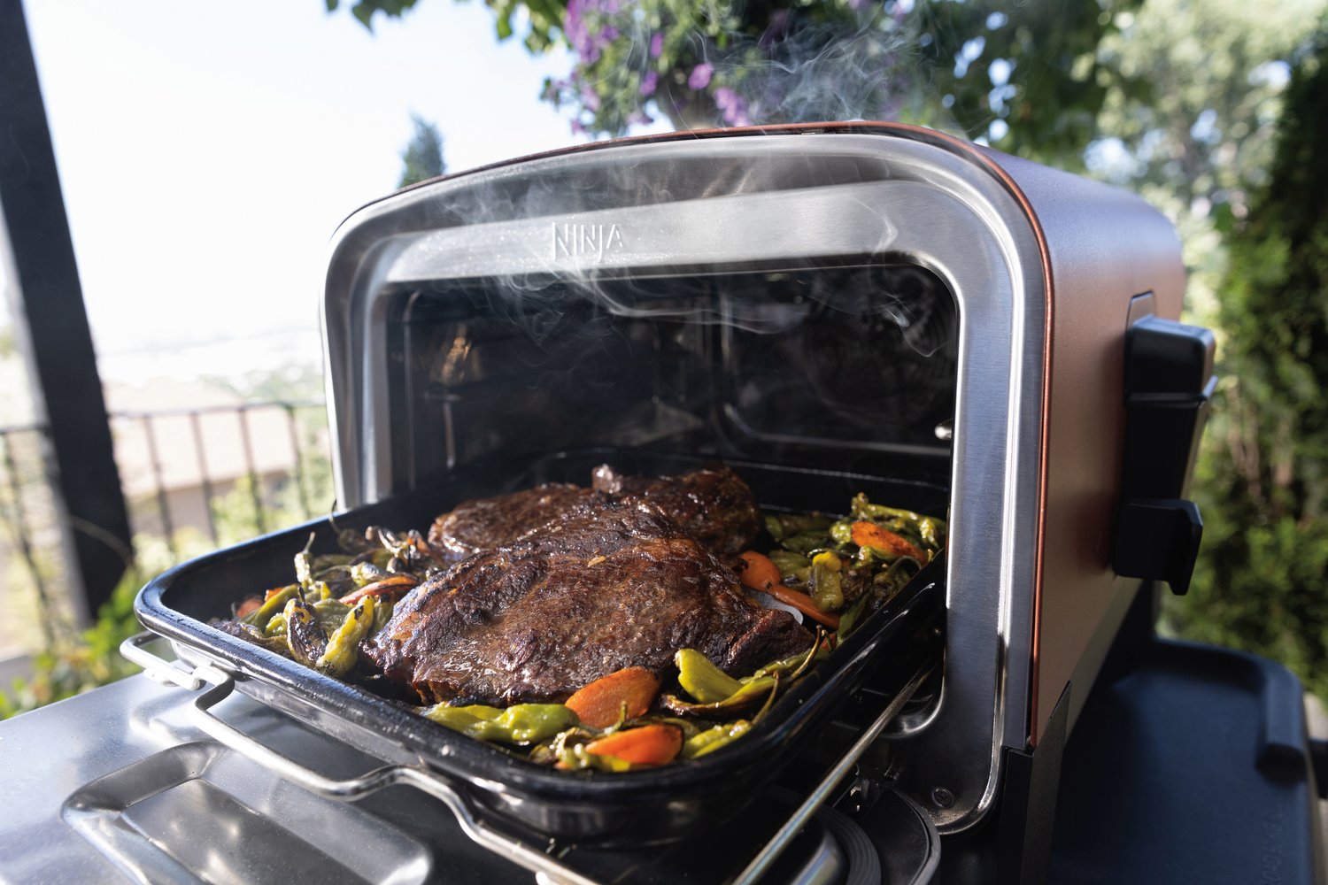Ninja-R_OO101UK_InUse_Balcony_OnStand_Open_SteakVeggies+RGB